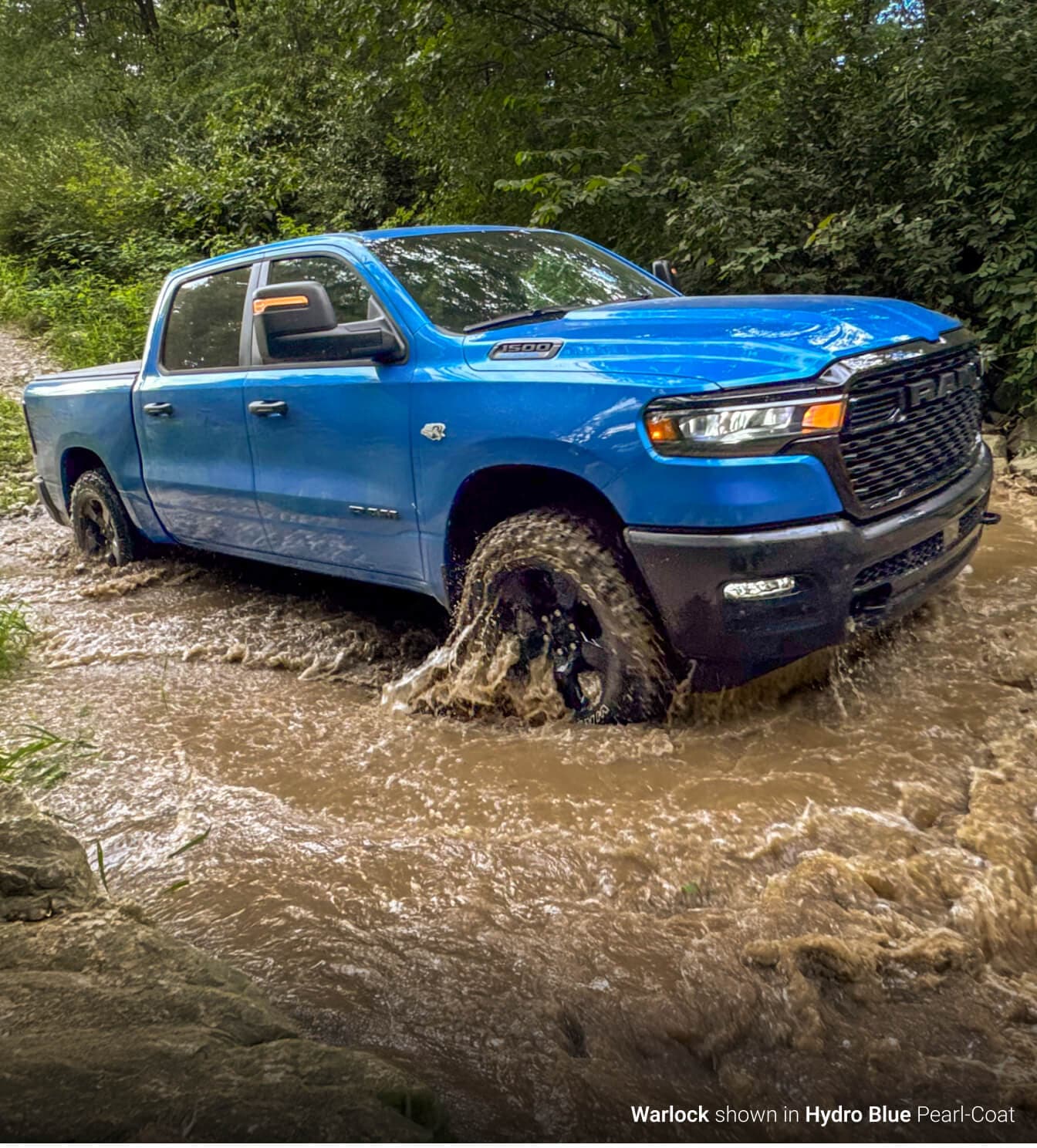 Ram 1500 Warlock in Hydro Blue off-roading through mud and watery terrain