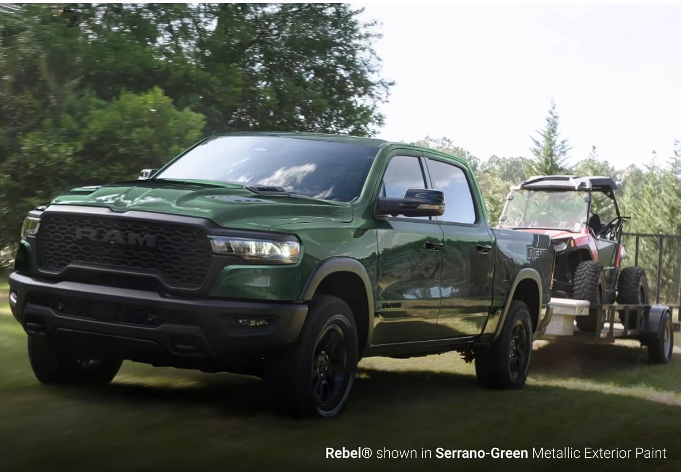 2026 Ram 1500 Rebel in Serrano Green towing a utility vehicle off-road