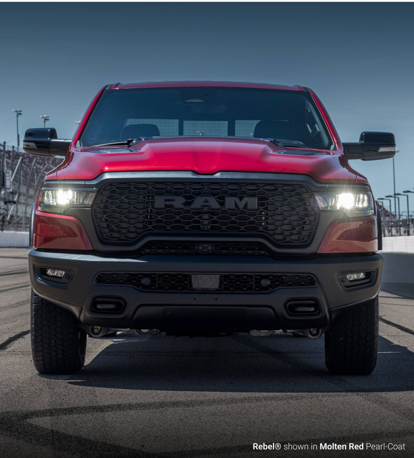 Front view of a Ram 1500 Rebel in Molten Red on a race track