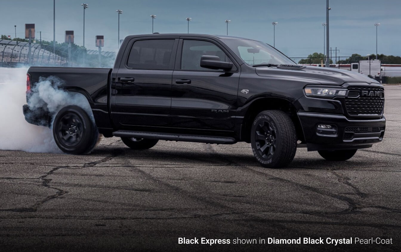 2026 Ram 1500 Black Express in Diamond Black peeling out on a race track