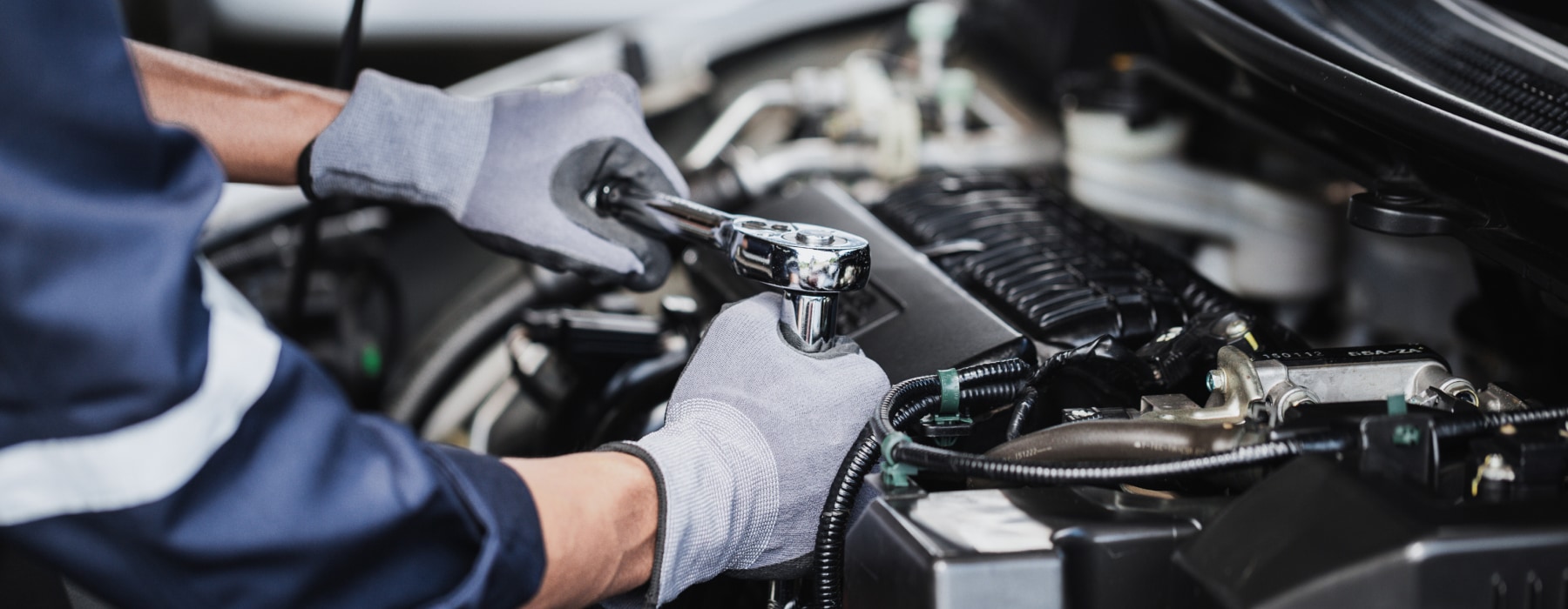 Close-up shot of a Chevrolet service technician working on the engine of a Chevy