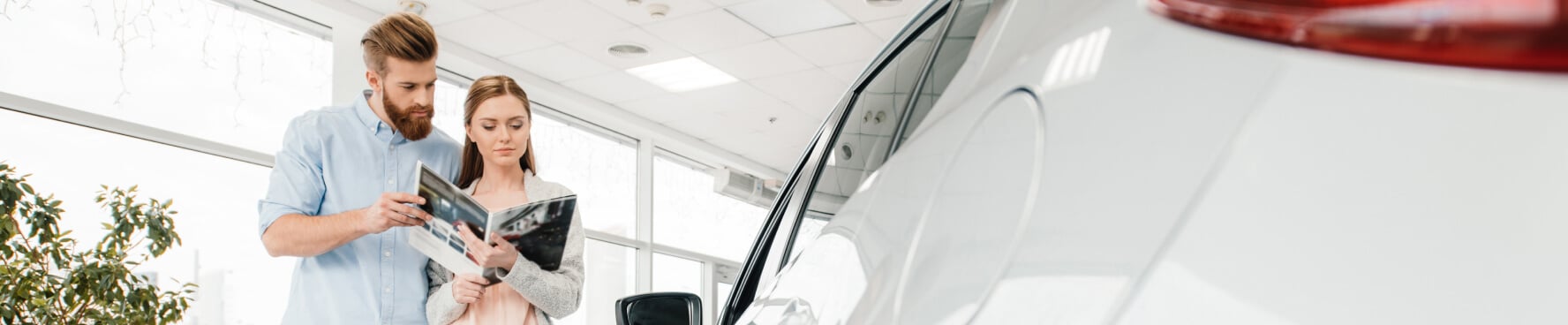 Man and woman reviewing the brochure inside a new Chevrolet dealership
