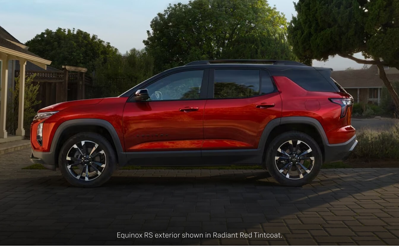 Side profile view of a red Chevrolet Equinox RS with a black roof parked on a paved residential.