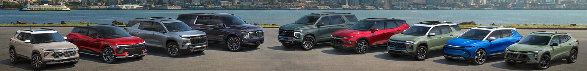 The full 2026 Chevrolet Lineup of Vehicles parked in front of water with a ferry in the background