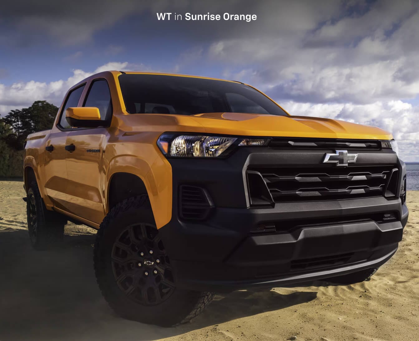 Front view of a 2026 Chevrolet Colorado WT in Sunrise Orange Sands parked on a beach