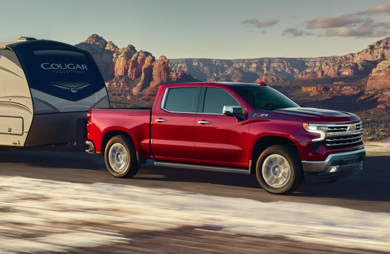 Chevrolet Silverado LTZ in red towing a trailer in the desert