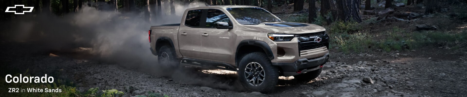 2026 Chevrolet Colorado ZR2 in White Sands off-roading through muddy terrain
