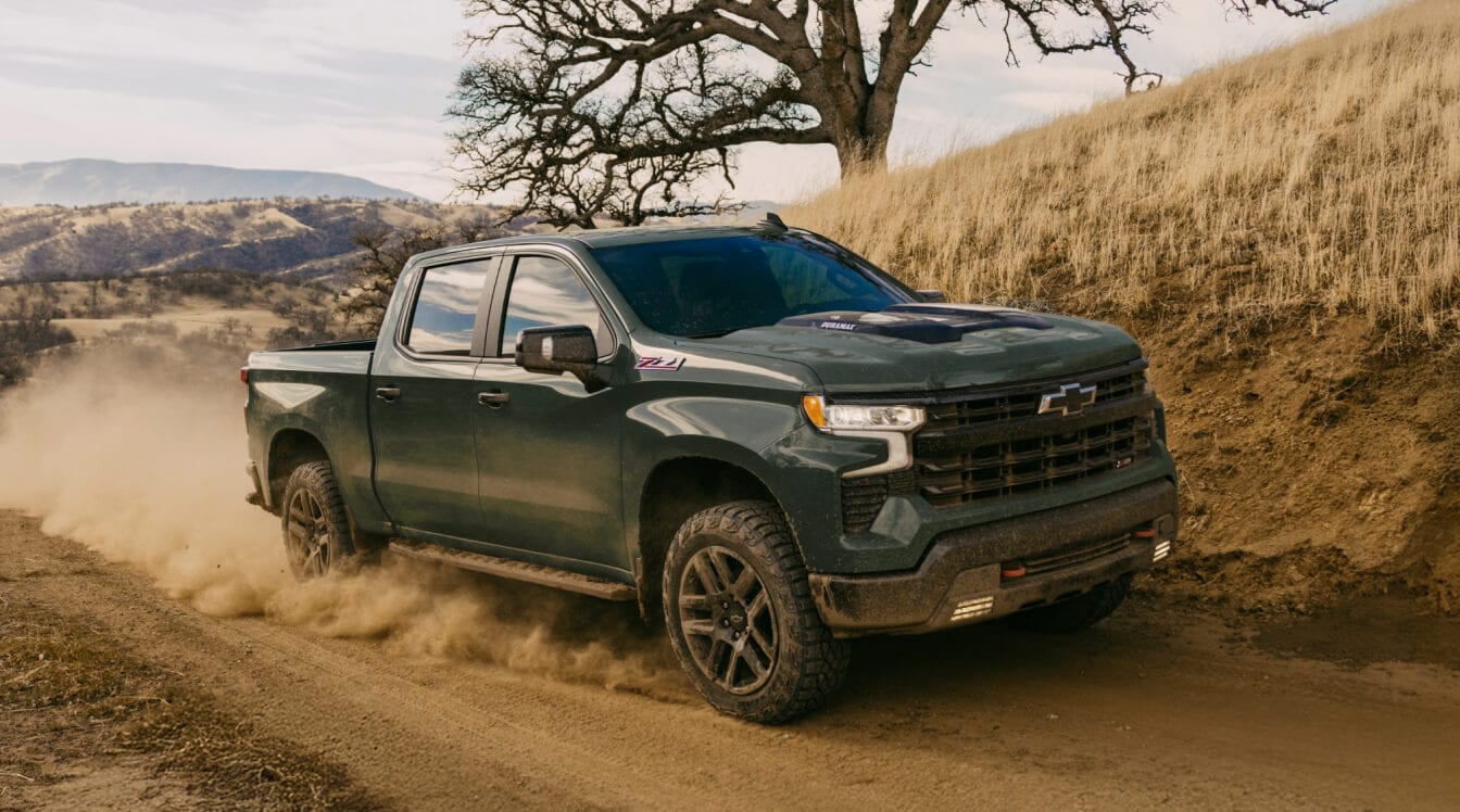 New 2025 Chevrolet Silverado 1500 Crew Cab LT featured in Cypress Gray driving around a sandy bend