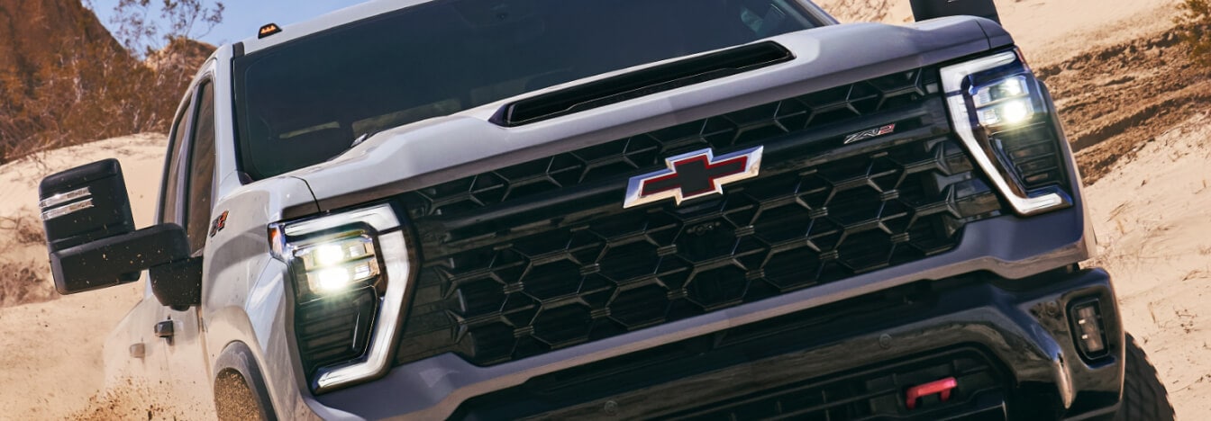 Close-up of the front and grille of a 2025 Chevrolet Silverado 2500 Crew Cab ZR2 in Slate Gray Metallic.