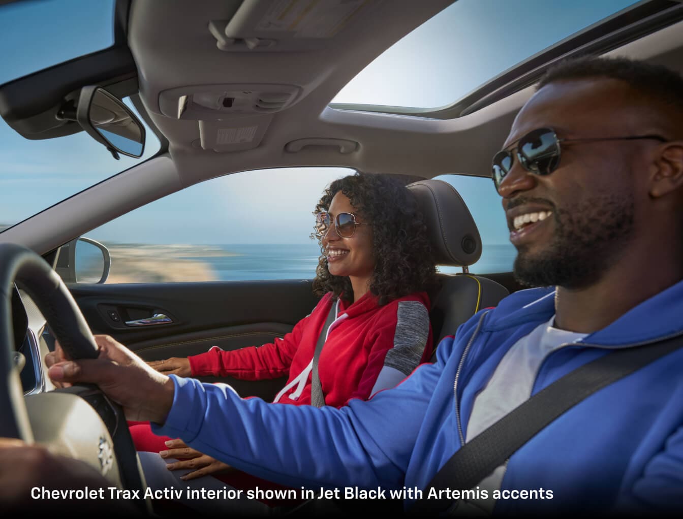 A man and woman in their 2026 Chevy Trax on a sunny day