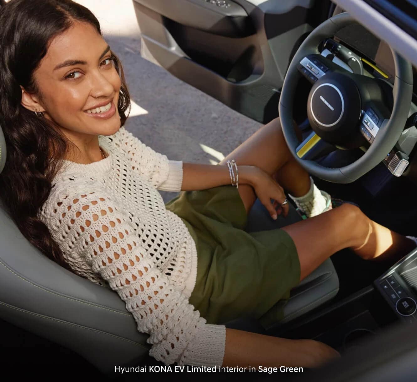 A woman sitting inside of her Hyundai KONA EV Limited featuring the new interior
