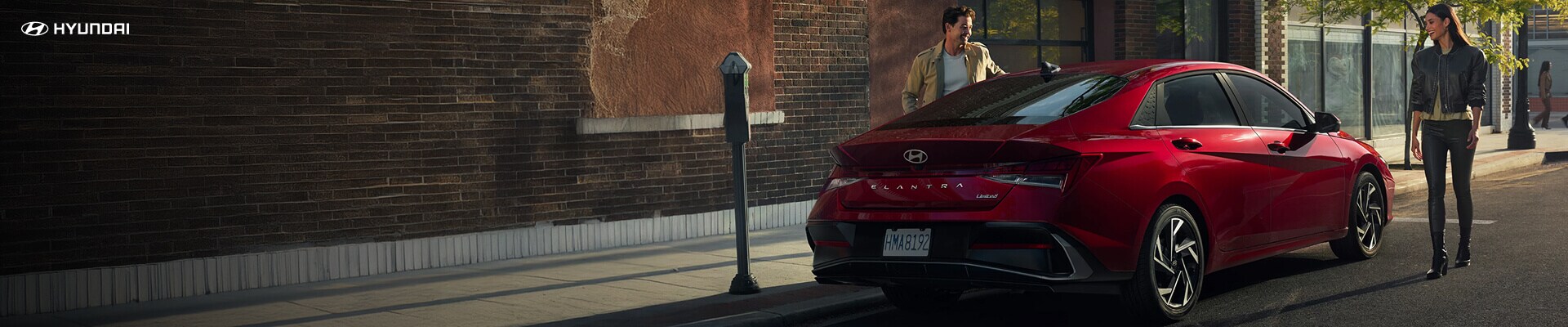 2026 Hyundai Elantra Limited in red parked outside a brick building