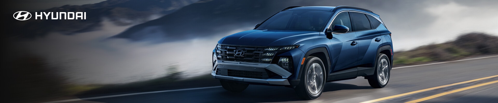 2026 Hyundai Tucson Limited in blue driving in front of mountains