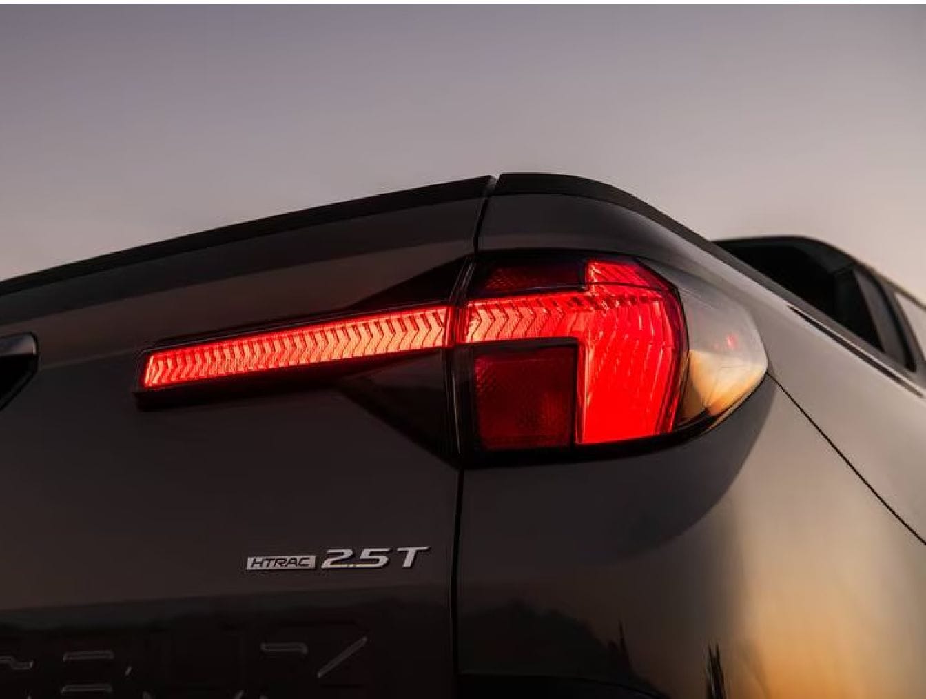 Close-up of the illuminated rear taillight on a Hyundai Santa Cruz.