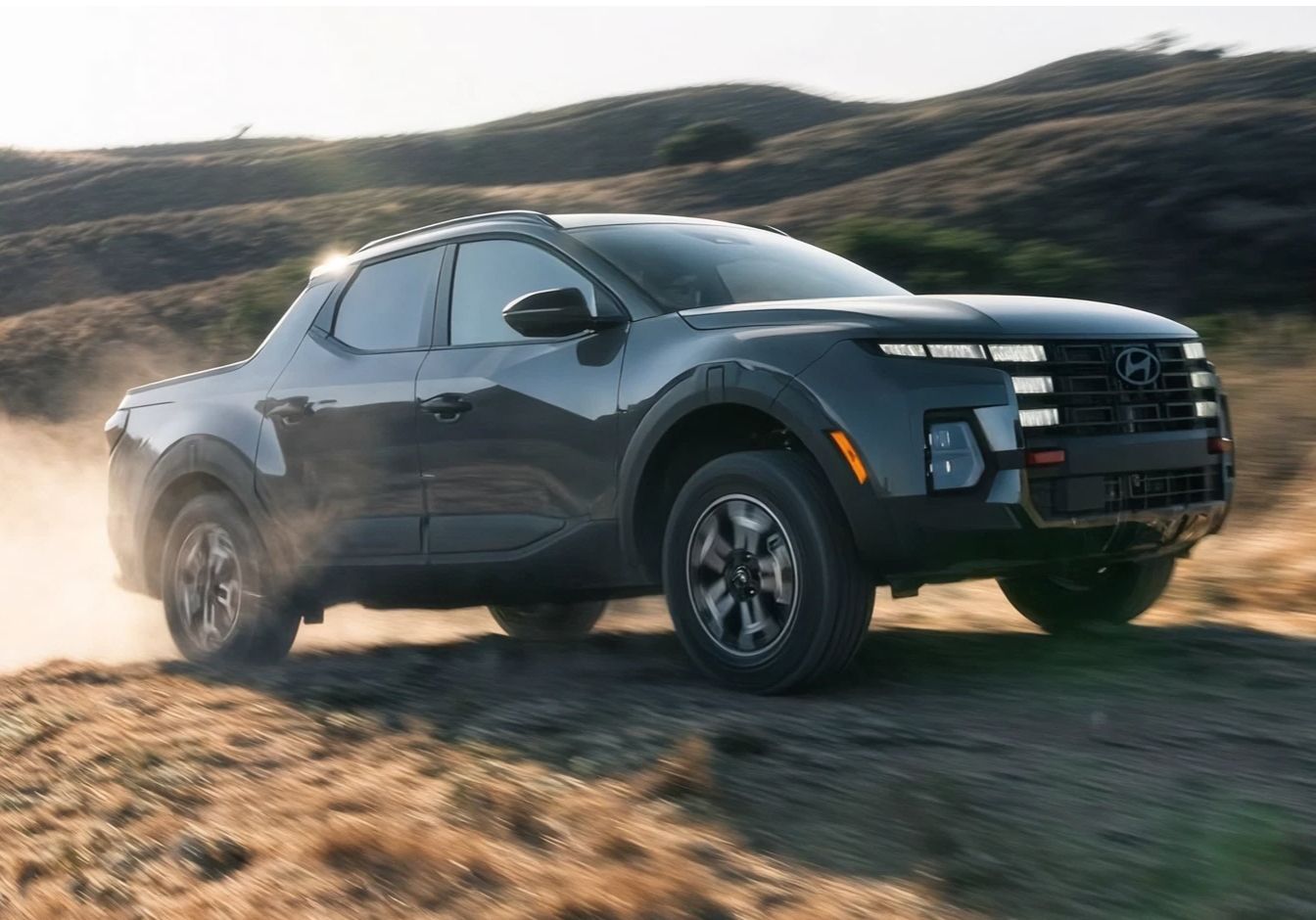 Hyundai Santa Cruz driving off-road on a rugged dirt trail.