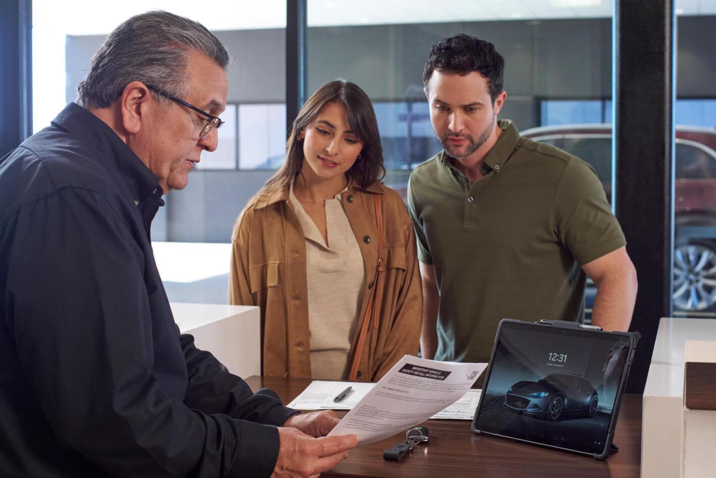 Couple reviewing paperwork with a Mazda service advisor