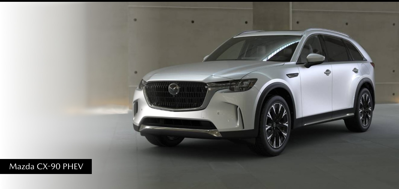 Mazda CX-90 PHEV in silver parked in front of a monotone backdrop