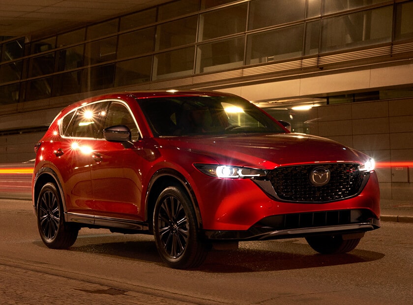 2025 Mazda CX-5 in Soul Red Crystal parked outdoors at night under dim lighting