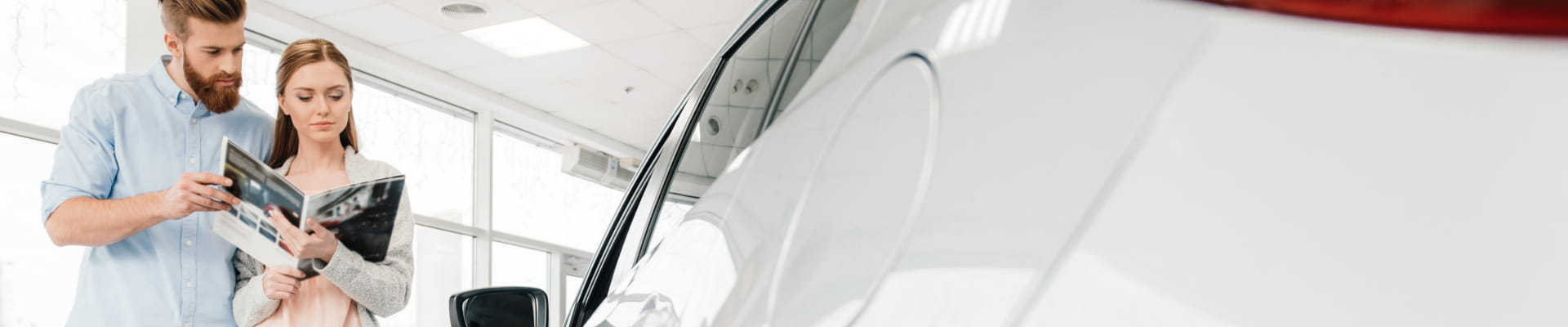Couple browsing a vehicle together at a dealership.