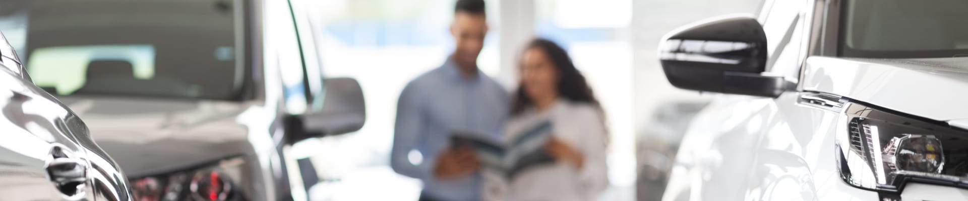 Couple browsing vehicles together in a dealership showroom.