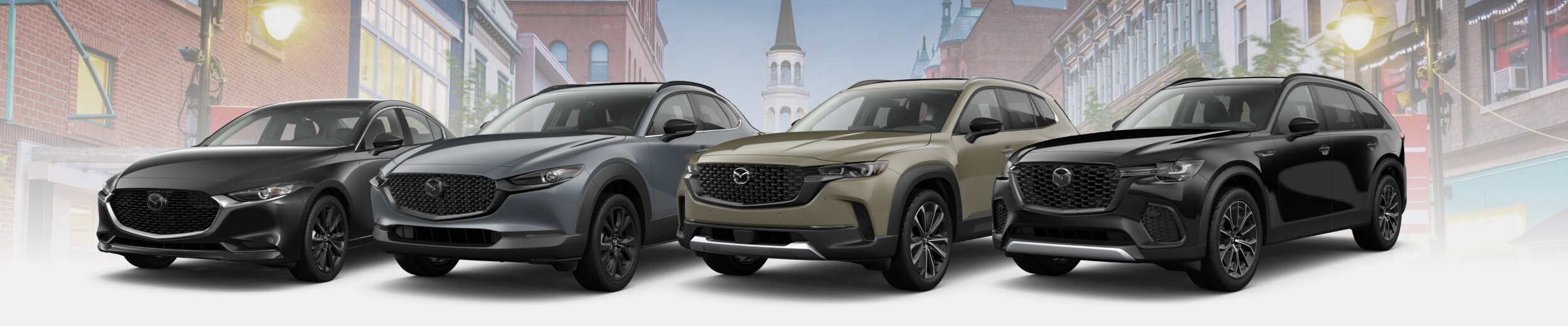 Four new Mazda vehicles in front of a South Burlington, Vermont landscape