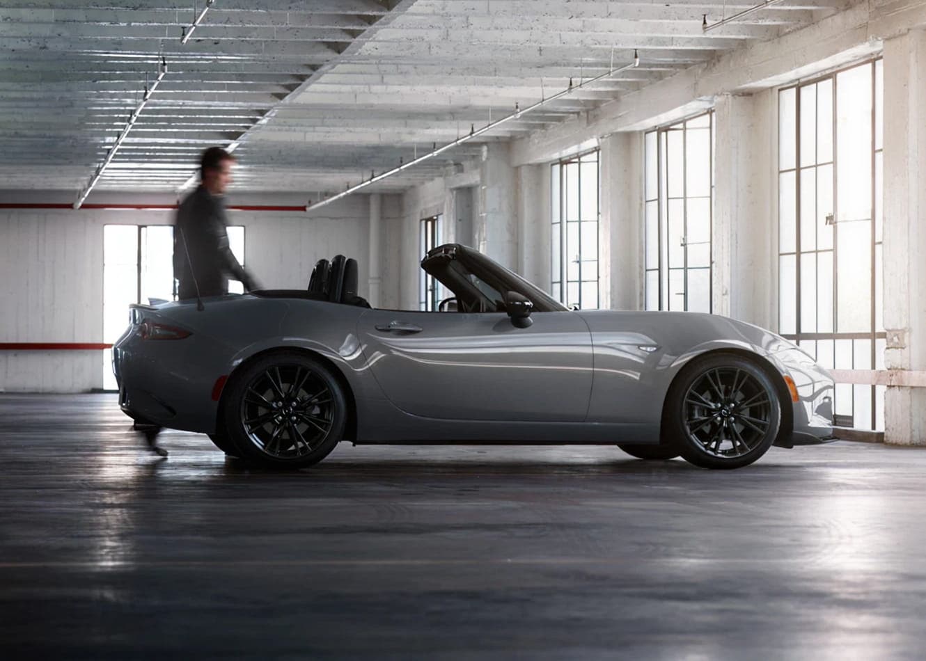 Man approaching a 2026 Mazda MX-5 Miata inside of a parking garage