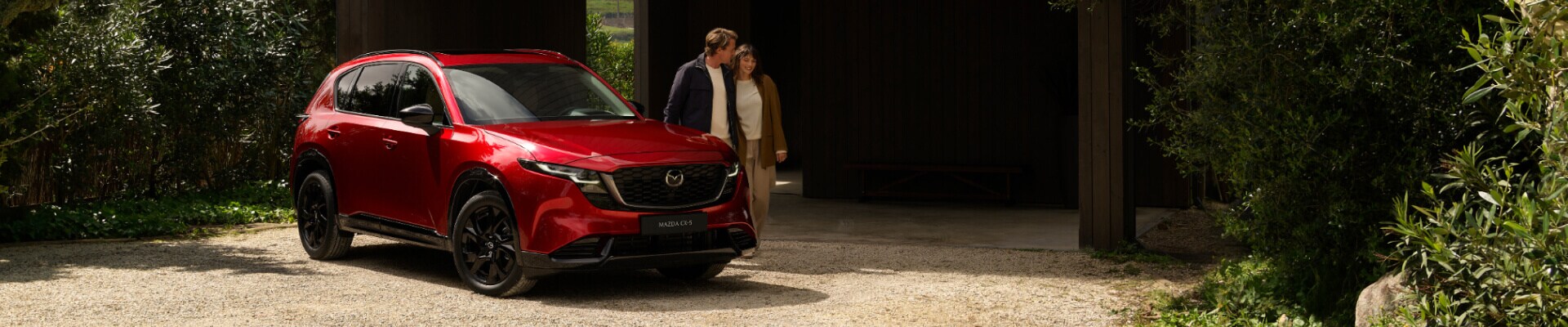 A couple walking by their 2026 Mazda CX-5