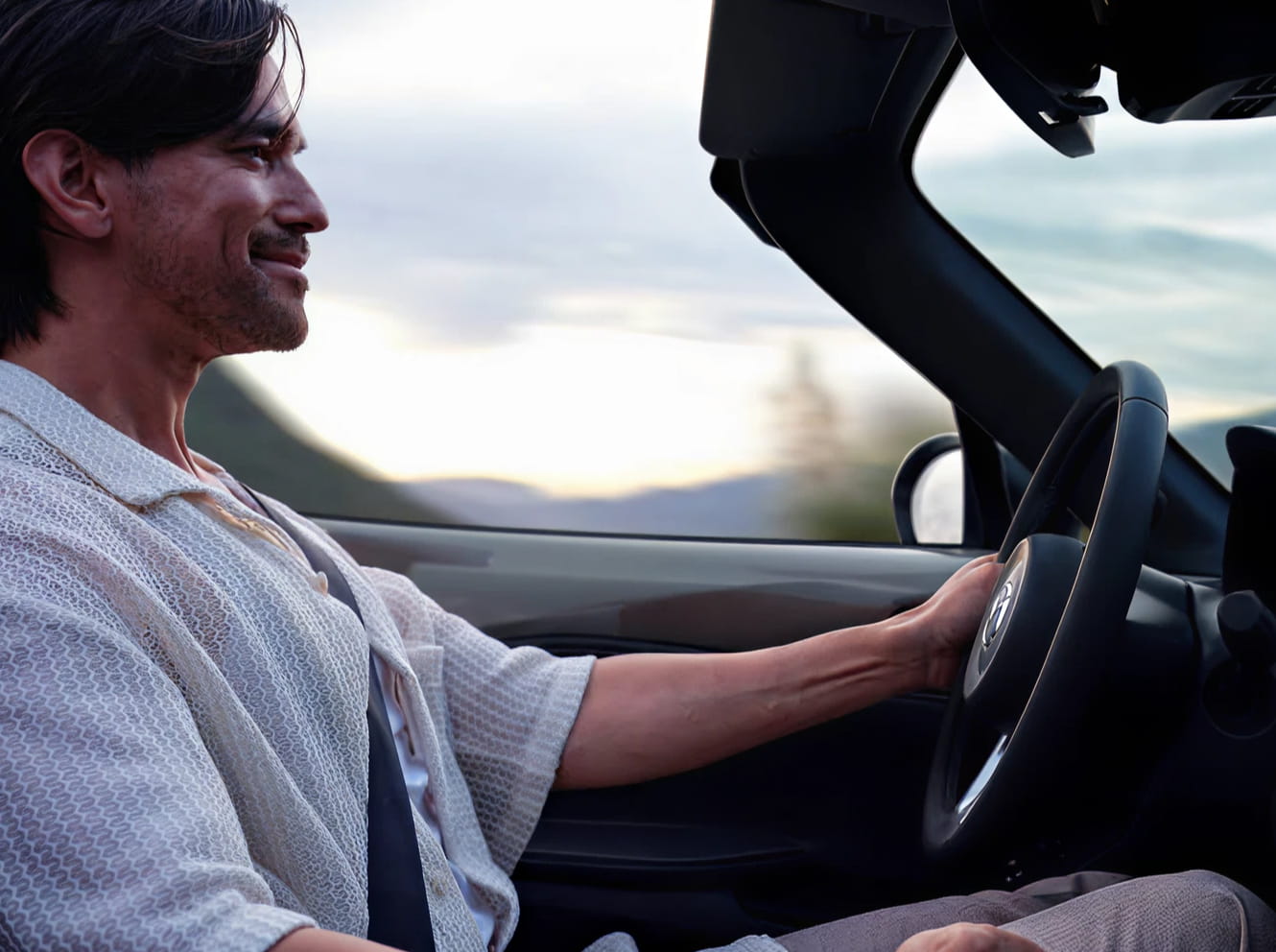 Man smiling as he drives a 2026 Mazda MX-5 Miata
