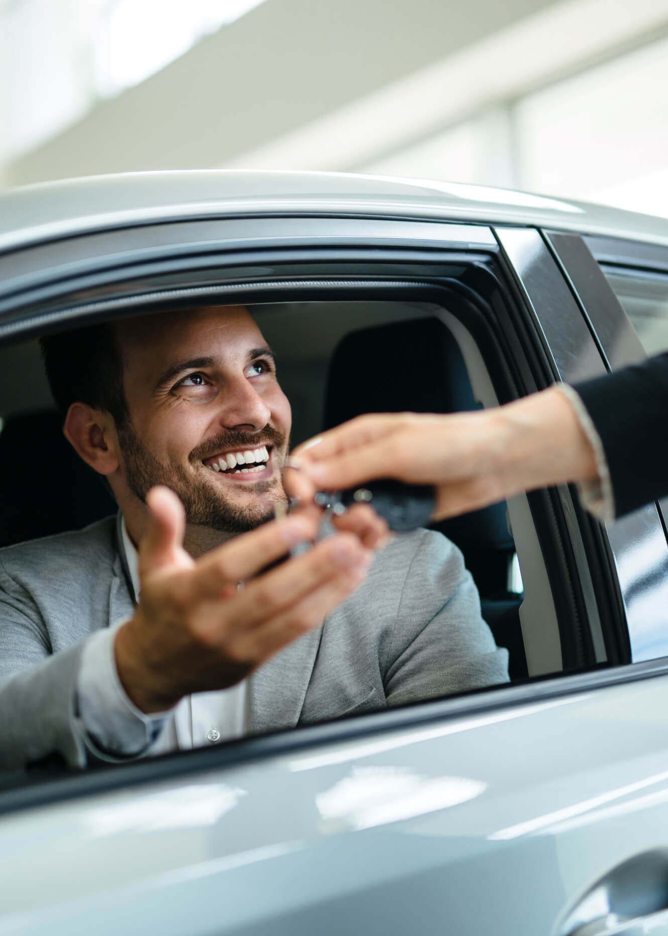 Man getting the keys to his new car purchase at a McGee Car Dealership
