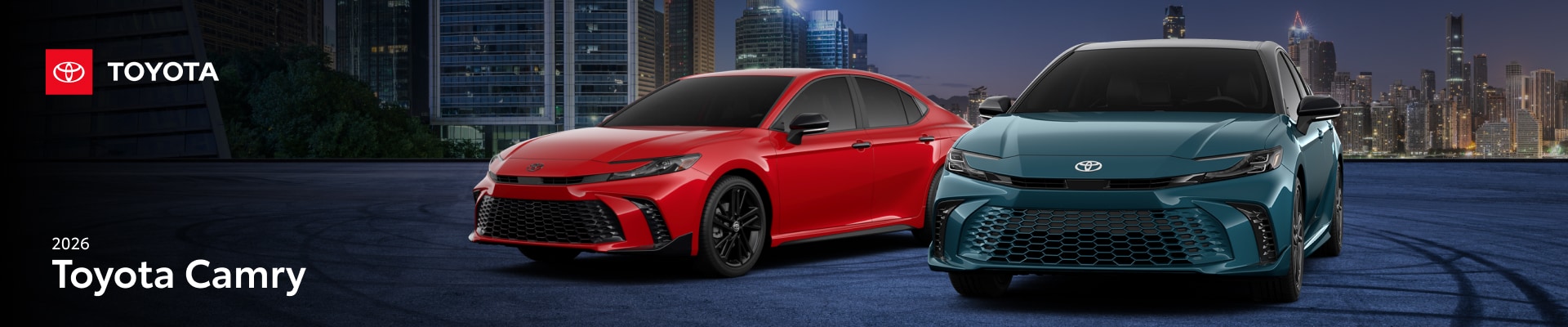 Two 2026 Toyota Camry sedans in front of a city landscape at night