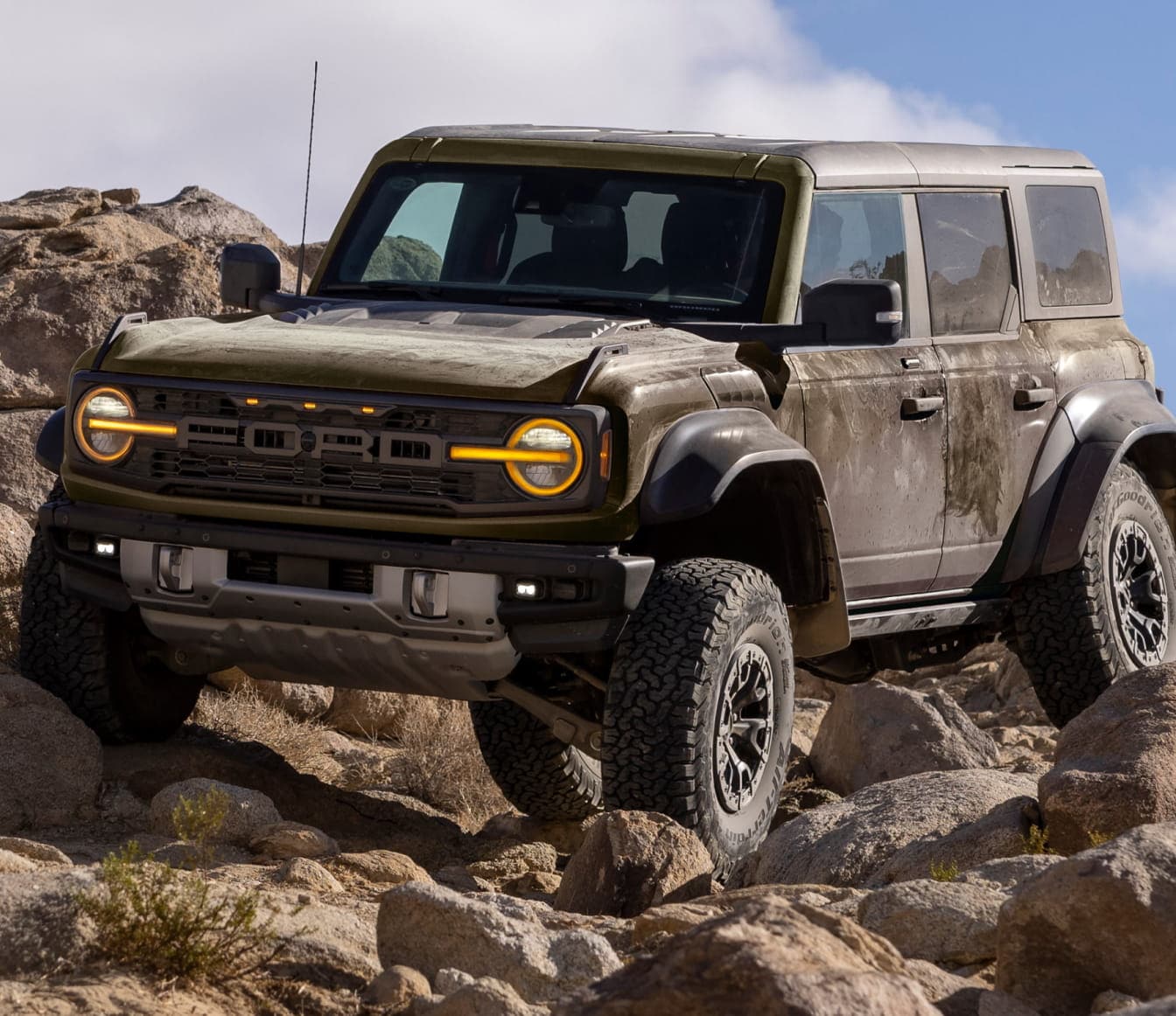 A dusty 2026 Ford Bronco Raptor parked atop rocky terrain.
