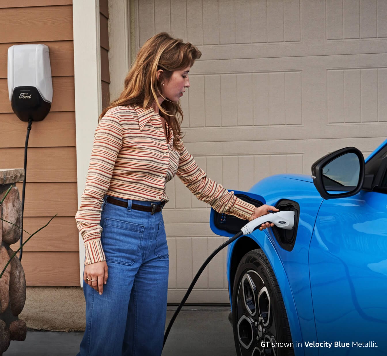 Woman charging her Mustang Mach E GT using her at-home Ford Wallbox EV Charging Station