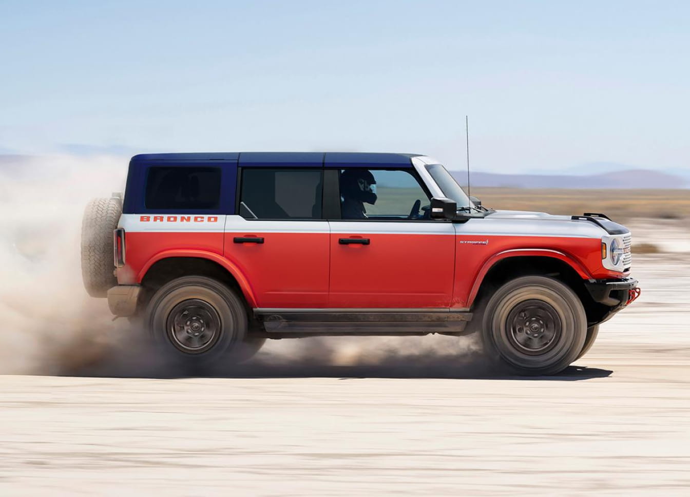 2026 Ford Bronco Stroppe Edition driving on sandy terrain, kicking up sand underneath and behind