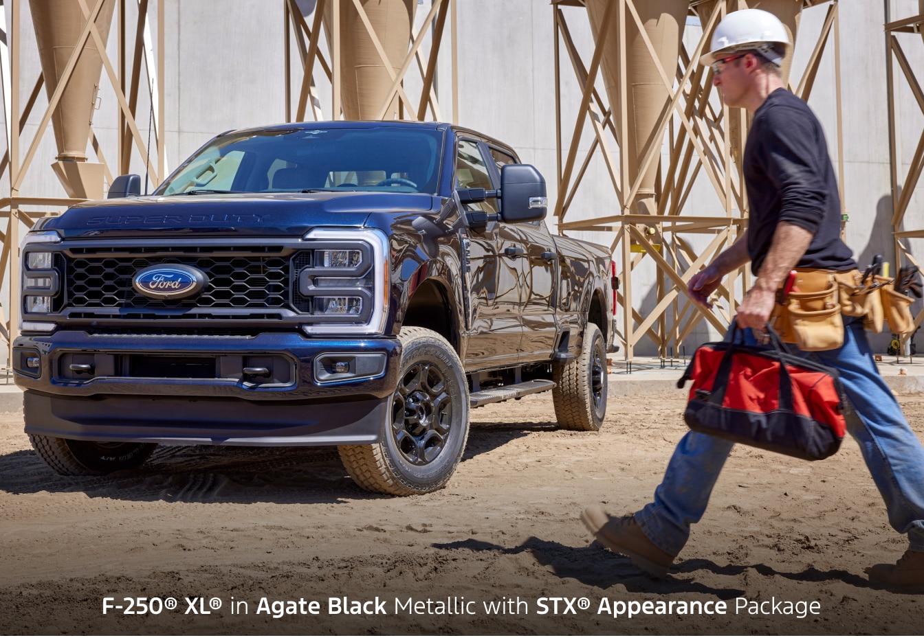 2026 Ford F-250 XL in Agate Black parked on a construction site with a construction worker walking nearby