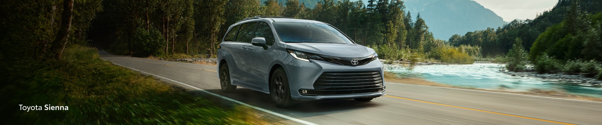 2026 Toyota Sienna Woodland Edition driving by a lake in the forest