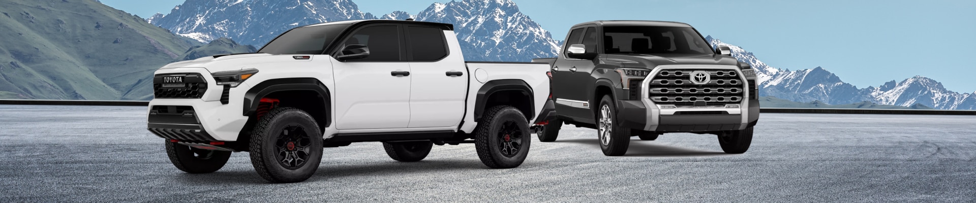 2025 Toyota Tacoma TRD-Pro in Ice Cap alongside a 2025 Toyota Tundra 1974 Edition in Lunar Rock
