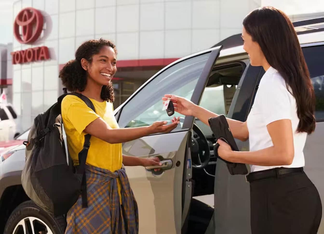 Toyota saleswoman handing keys over to a female customer