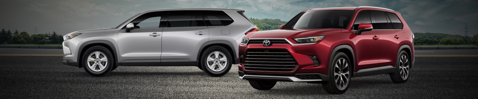 Two new 2026 Toyota Grand Highlander Hybrid SUVs, one in Silver and one in red
