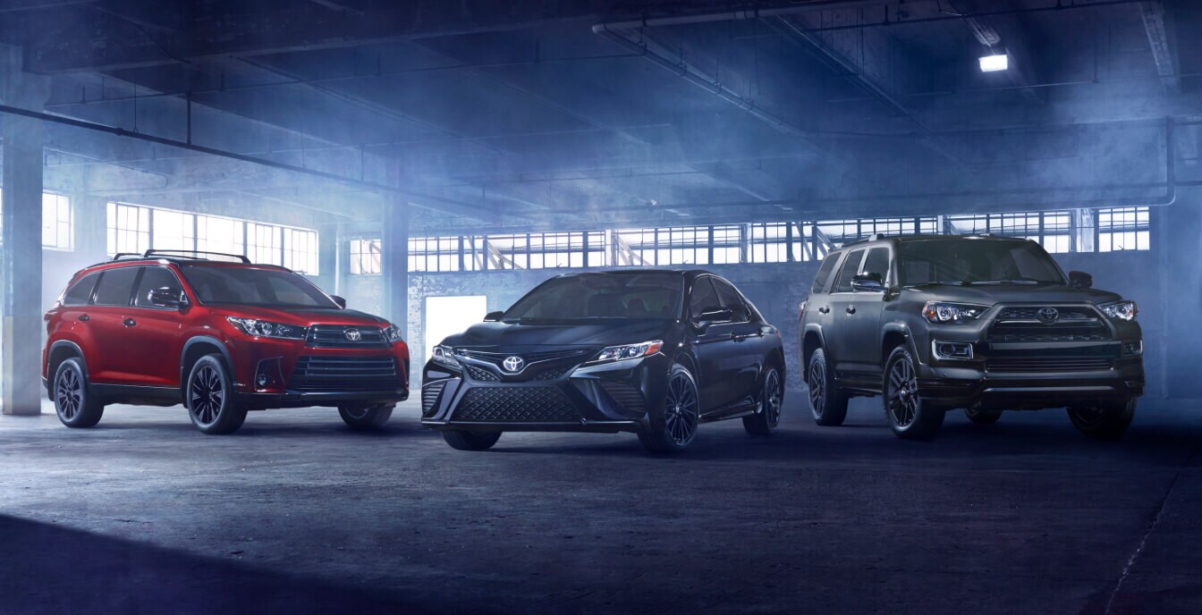 A 2020 Toyota Corolla, Camry and 4Runner parked in a dark and foggy industrial building.