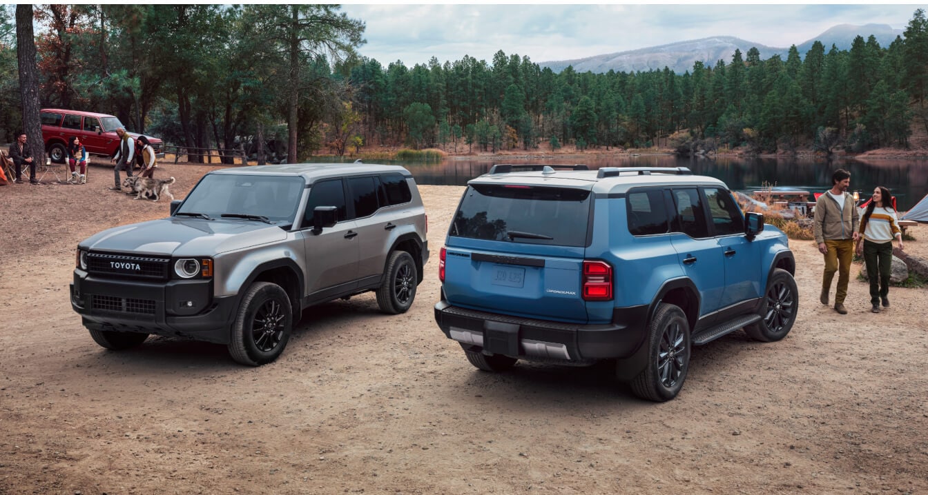 Two 2024 Landcruiser models parked at a campsite as people set up camp nearby.