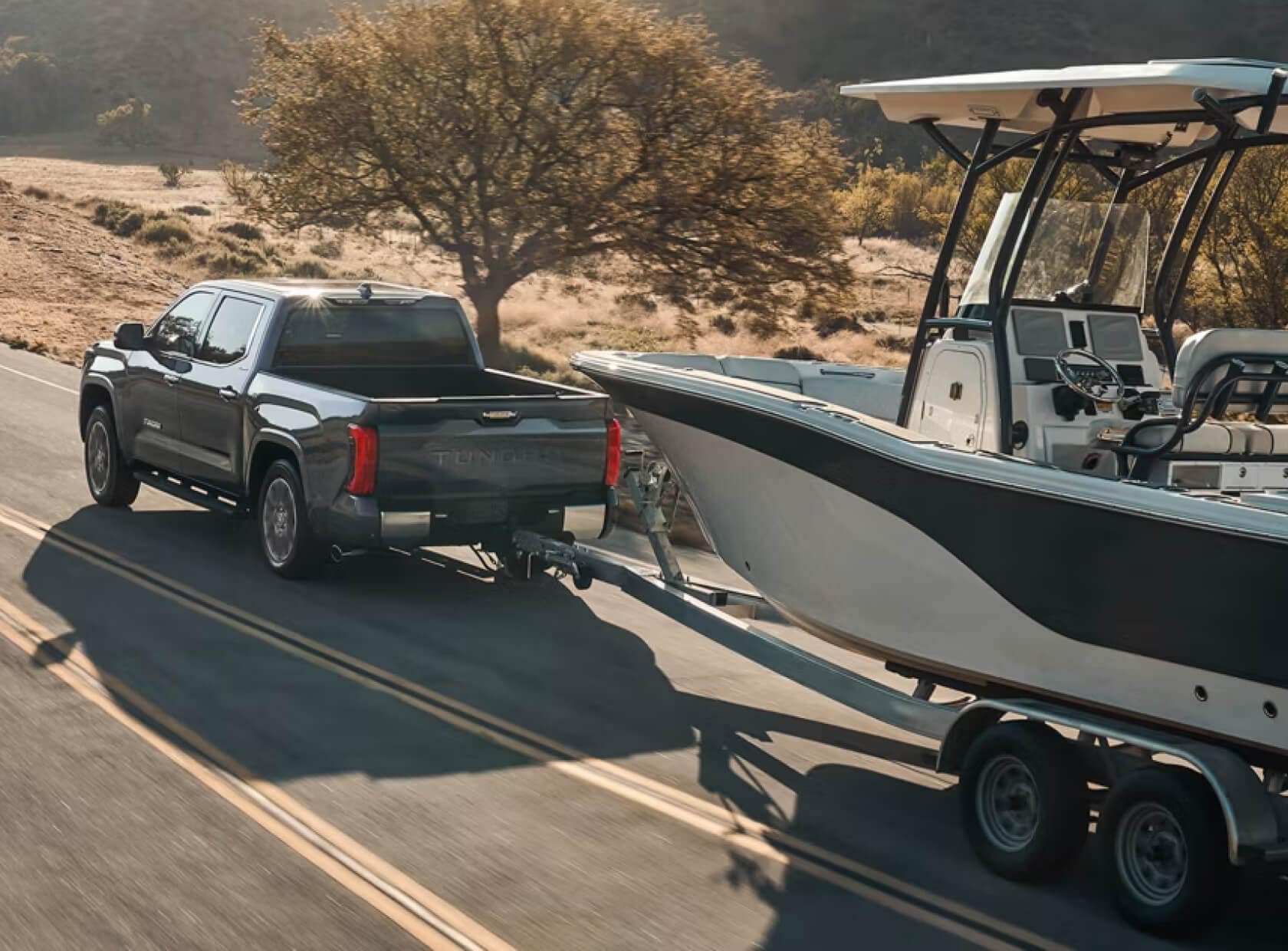 Toyota Tacoma Limited CrewMax in Magnetic Gray Metallic towing a boat through the desert