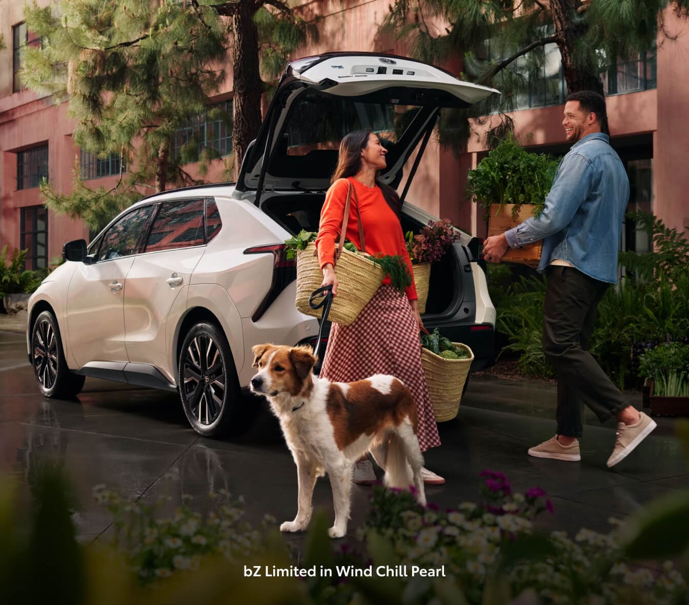 A couple and their dog exiting a 2026 Toyoat bZ Limited in White