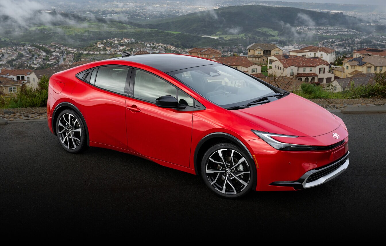 Toyota Prius Limited parked on an asphalt overlook in a coastal hillside neighborhood.