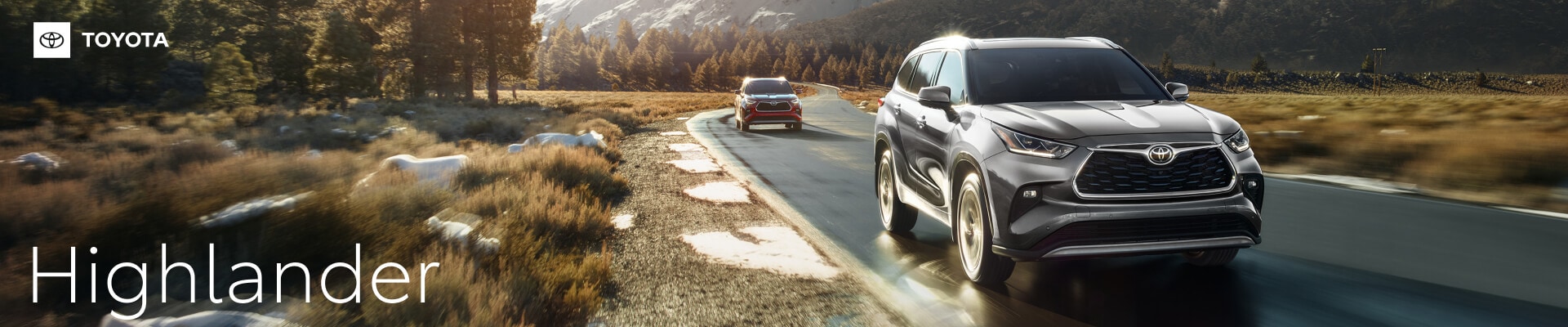 Front quarter view of a 26 Toyota Highlander in Heavy Metal driving fast on a mountain road.