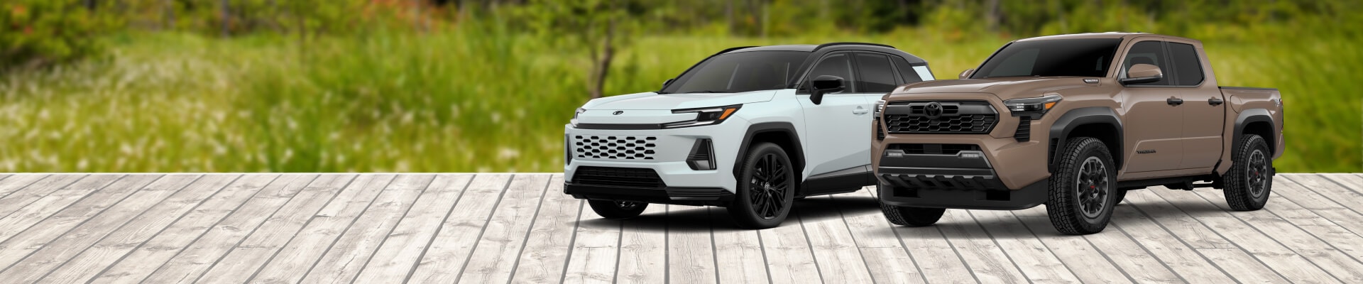 2026 Toyota RAV4 & Toyota Tacoma Parked in front of a woodsy landscape