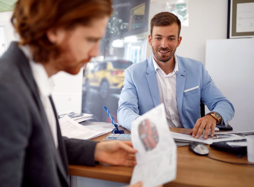 Toyota sales associate helping a customer with a Toyota brochure