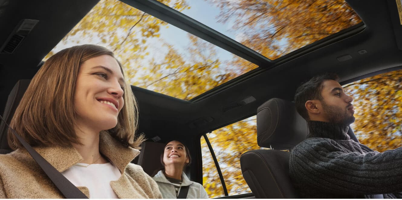Interior view of a 2026 Toyota Sequoia Platinum showing a family looking up through the panoramic sunroof.