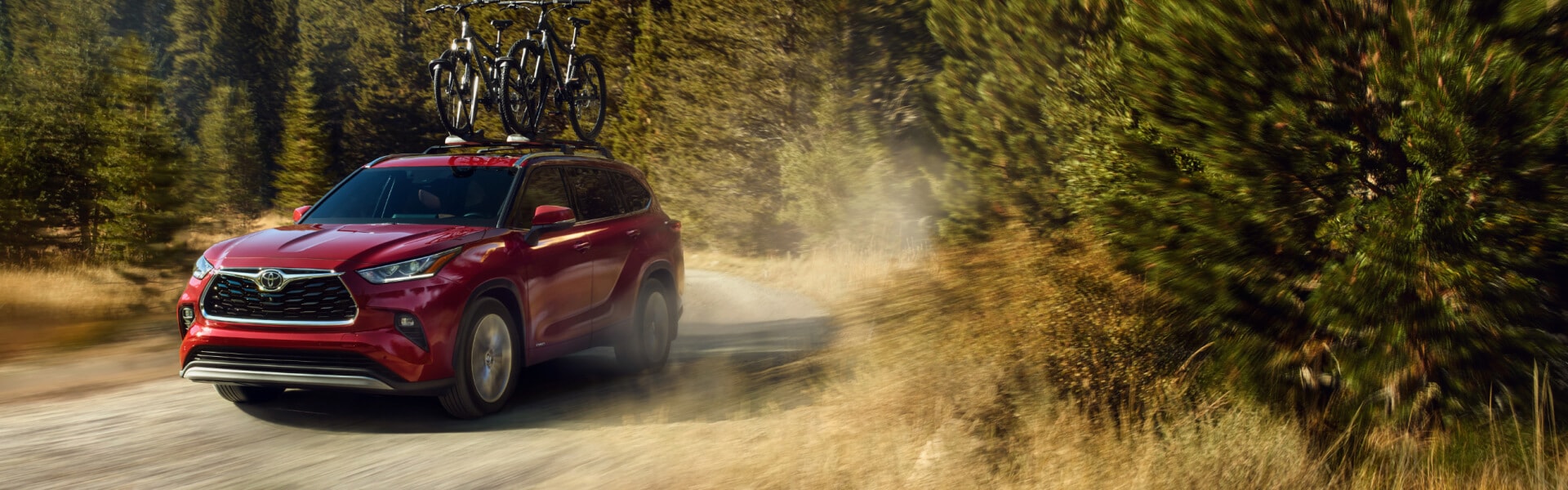 2026 Toyota Grand Highlander Hybrid in Dark Blue with a cloudy cityscape background