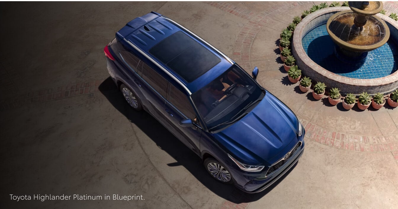 High angle view of a 26 Toyota Highlander Platinum in Blueprint parked next to a stone fountain.