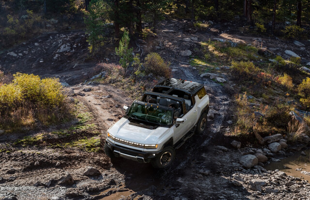 GMC Hummer EV SUV driving through mud